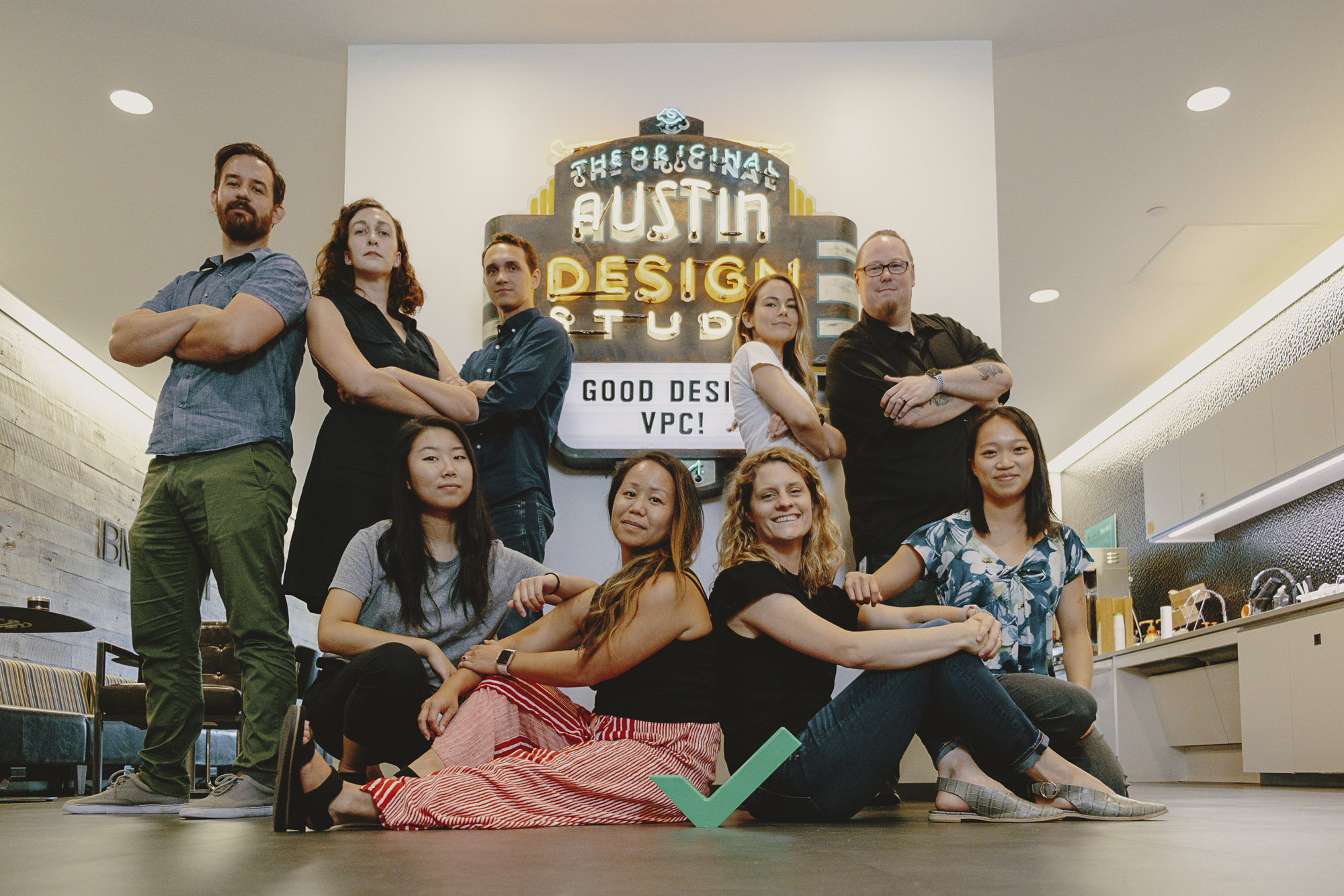 Picture of the design team posed together around a sign that says 'Good Design'